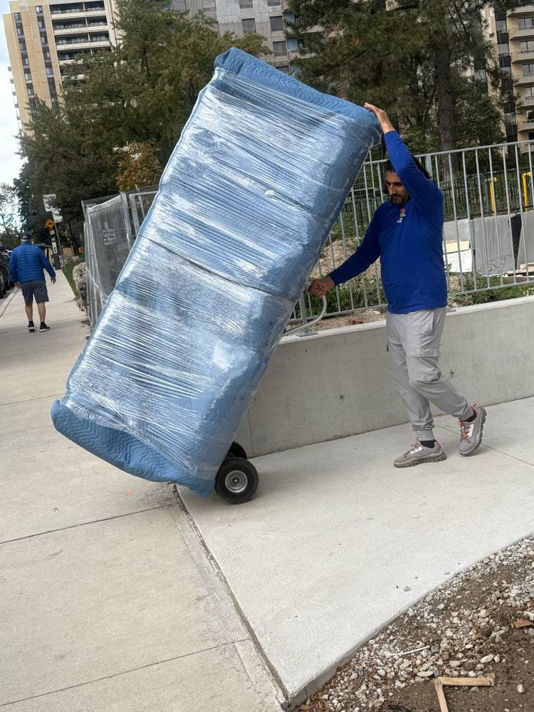 Movers carrying furniture from the sidewalk during a move in Markham