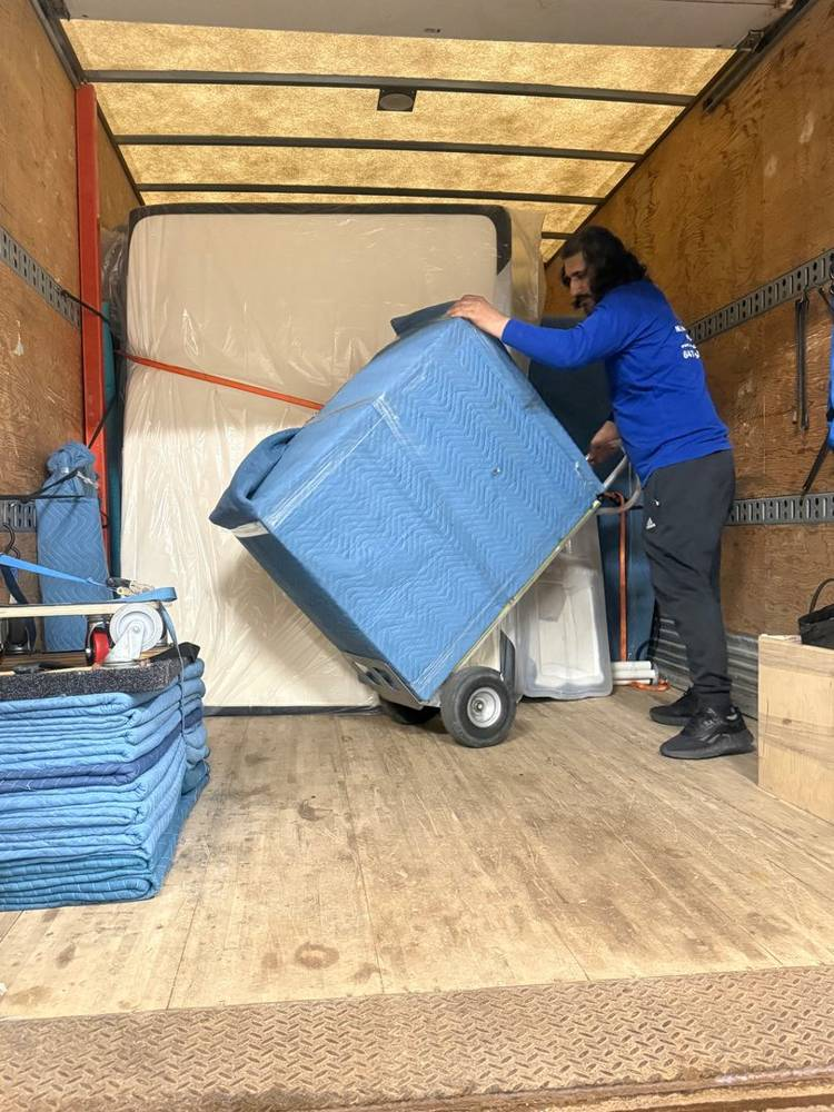 Mover using a dolly to load a truck for an office move in East York